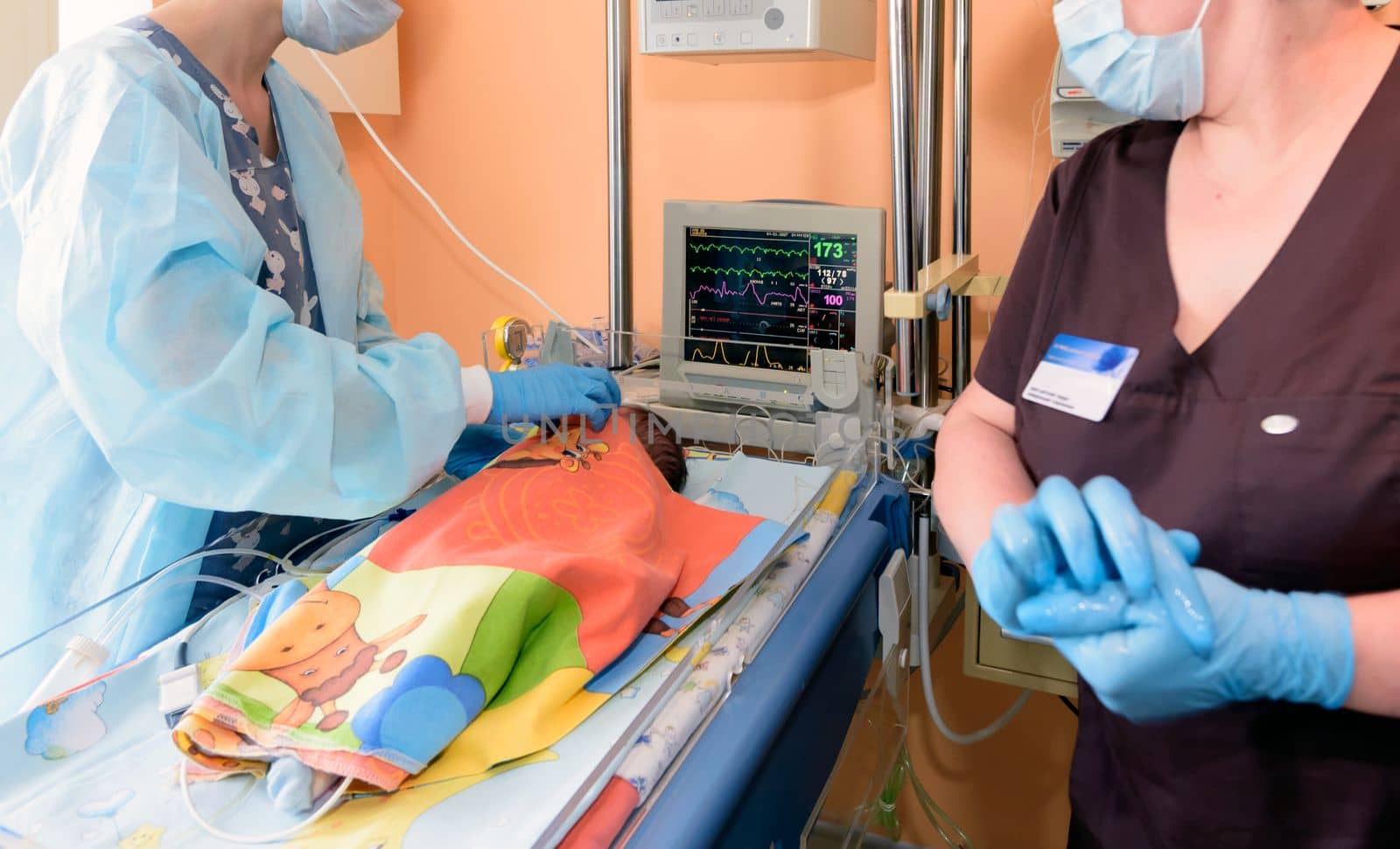 A young nurse caring for a newborn in a hospital in the intensive care unit.
