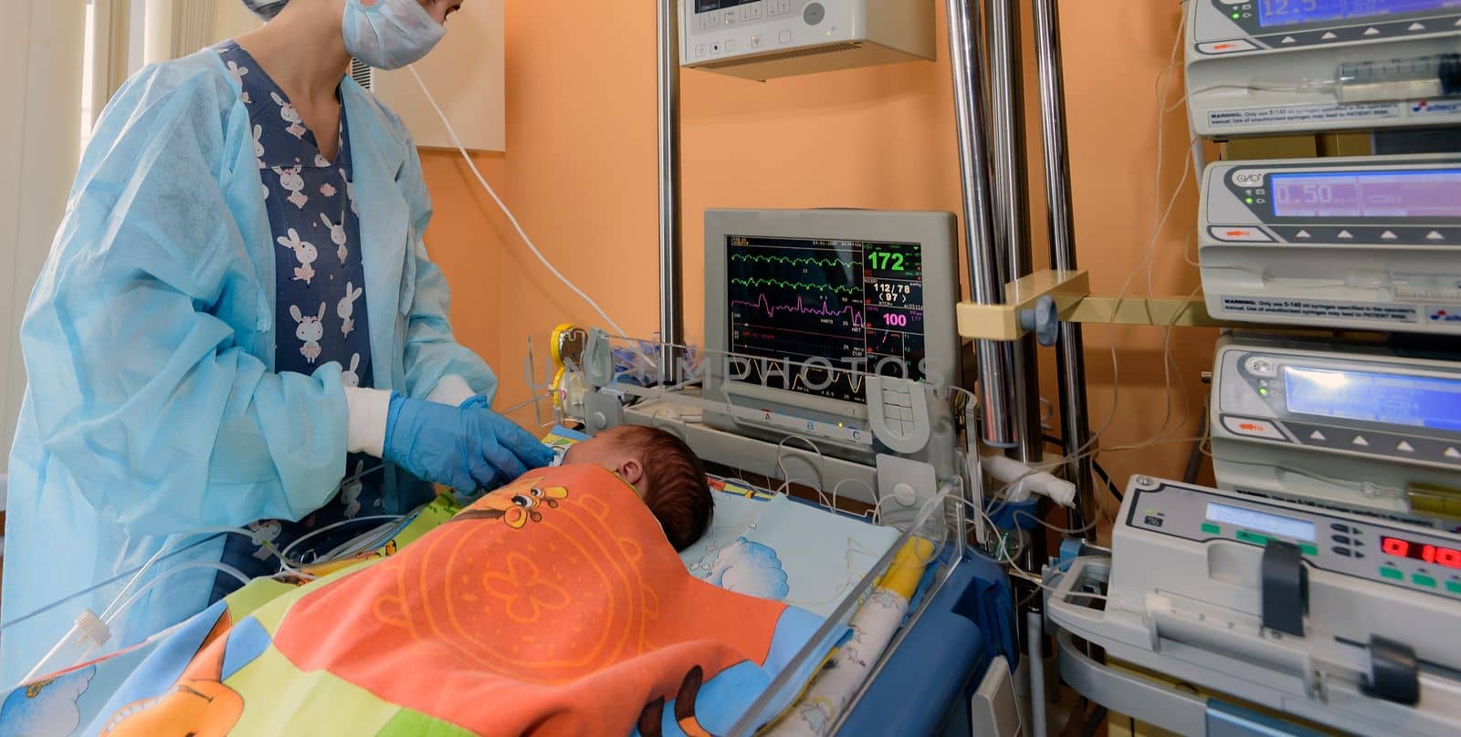 A young nurse caring for a newborn in a hospital in the intensive care unit.