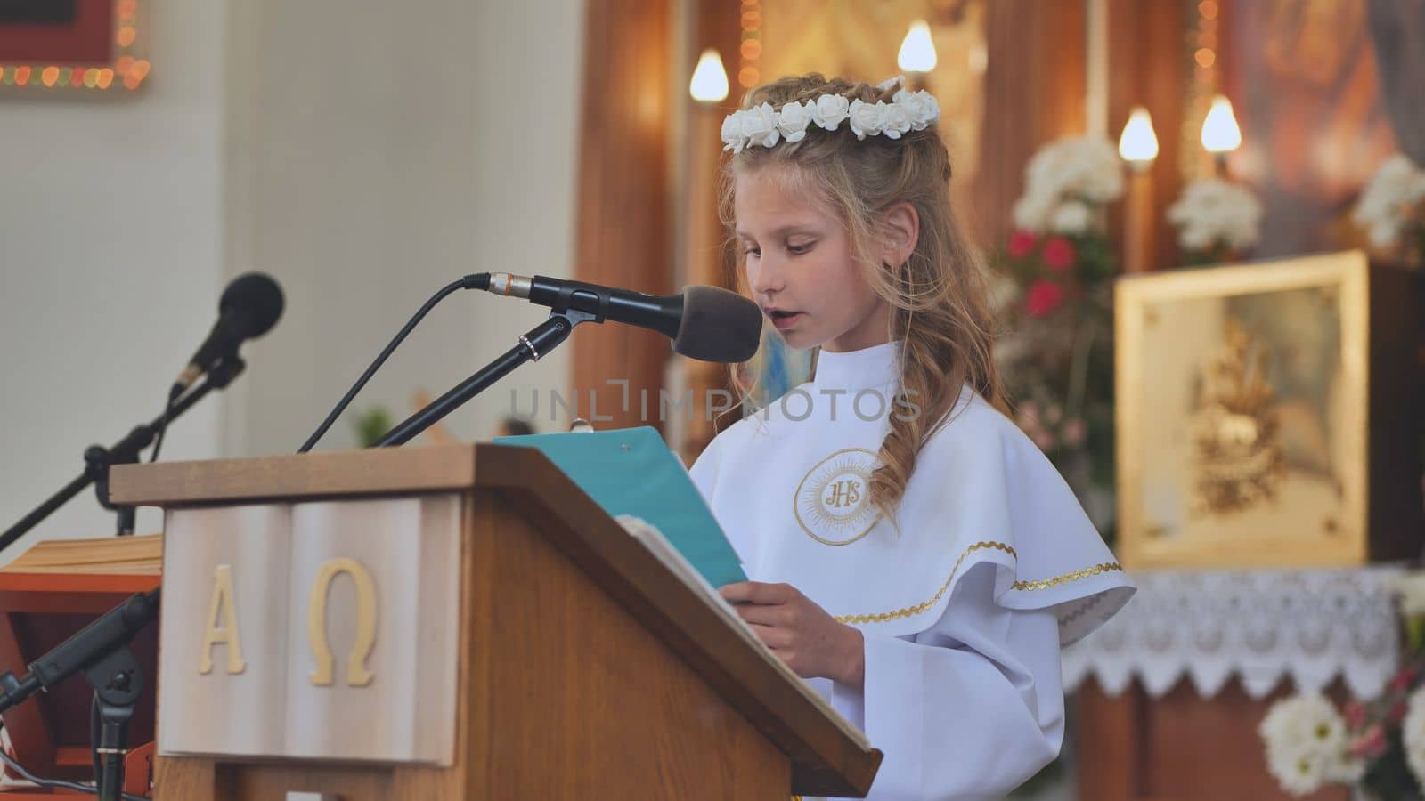 A girl reads the Bible at her First Catholic Communion.