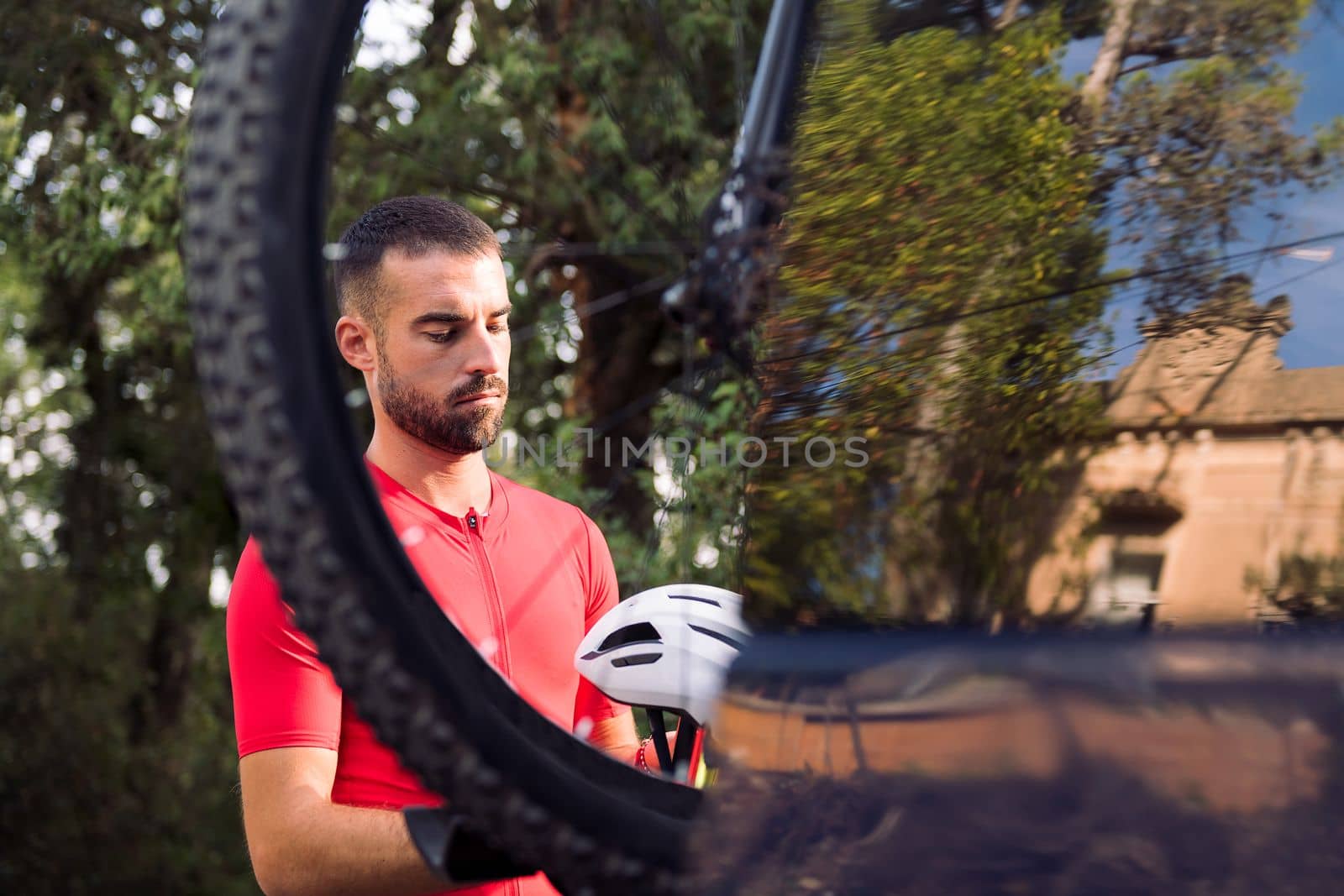 young man getting ready in cycling clothes next to his van to go training with his mountain bike, concept of freedom and sport in nature