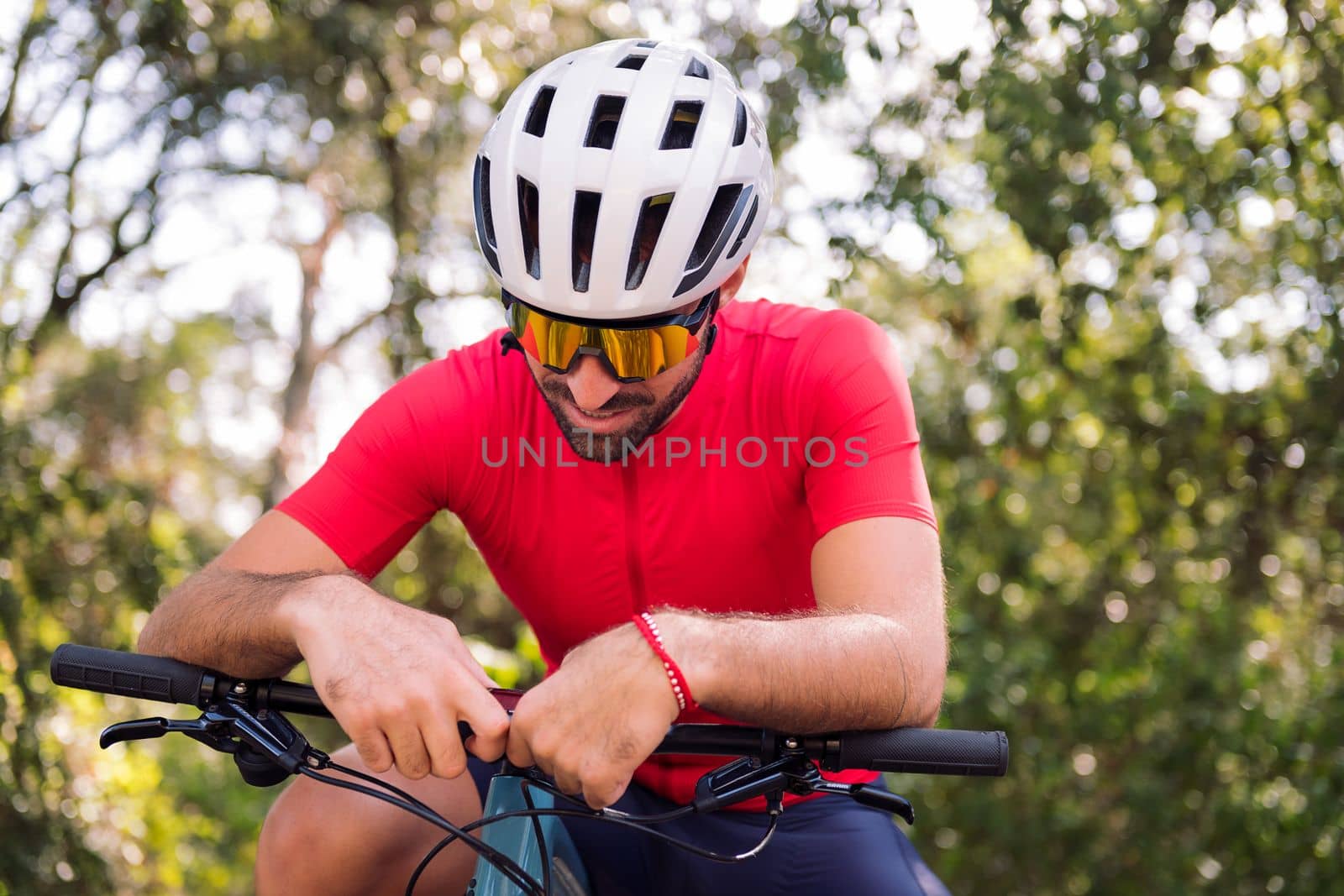young cyclist loading the route on his mountain bike navigator to go for a training ride, concept of freedom and sport in nature