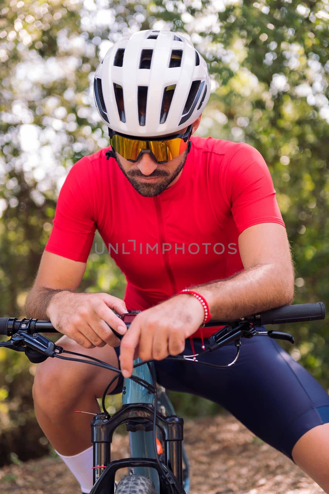 young cyclist loading the route on his mountain bike navigator to go for a training ride, concept of freedom and sport in nature