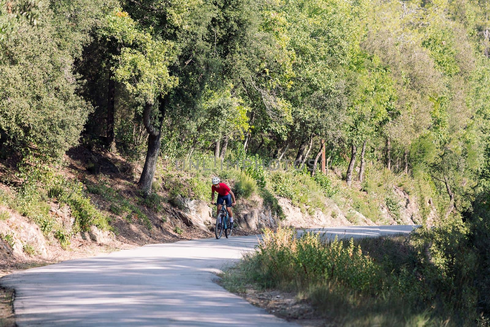 young cyclist training hard with his mountain bike on a forest road, concept of freedom and sport in nature, copy space for text