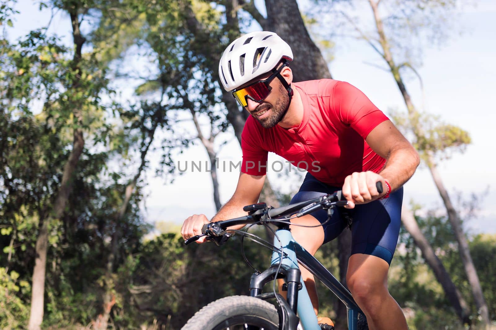 young cyclist training hard in the bush with his mountain bike, concept of freedom and sport in nature, copy space for text