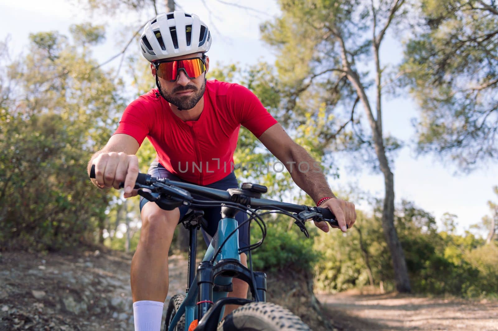 young cyclist training hard in the forest with his mountain bike, concept of freedom and sport in nature, copy space for text