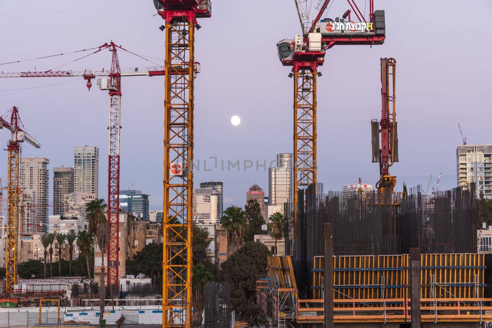 TEL AVIV, ISRAEL - MAY 01 2022: Somail complex in Tel Aviv in the evening with the moon rising. Construction work on the new Tel Aviv Municipality building. Ibn Gvirol Urban Renewals by avirozen