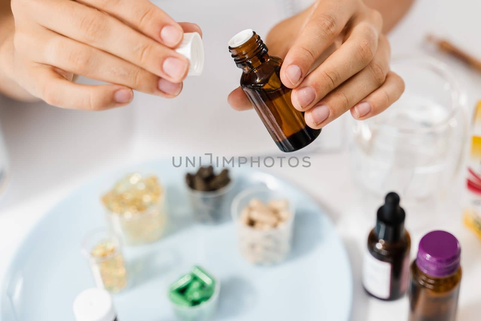 Face serum oil close-up in hands in gloves. Girl is holding face serum in hands for acne treatment and wrinkle smoothing. by Rabizo