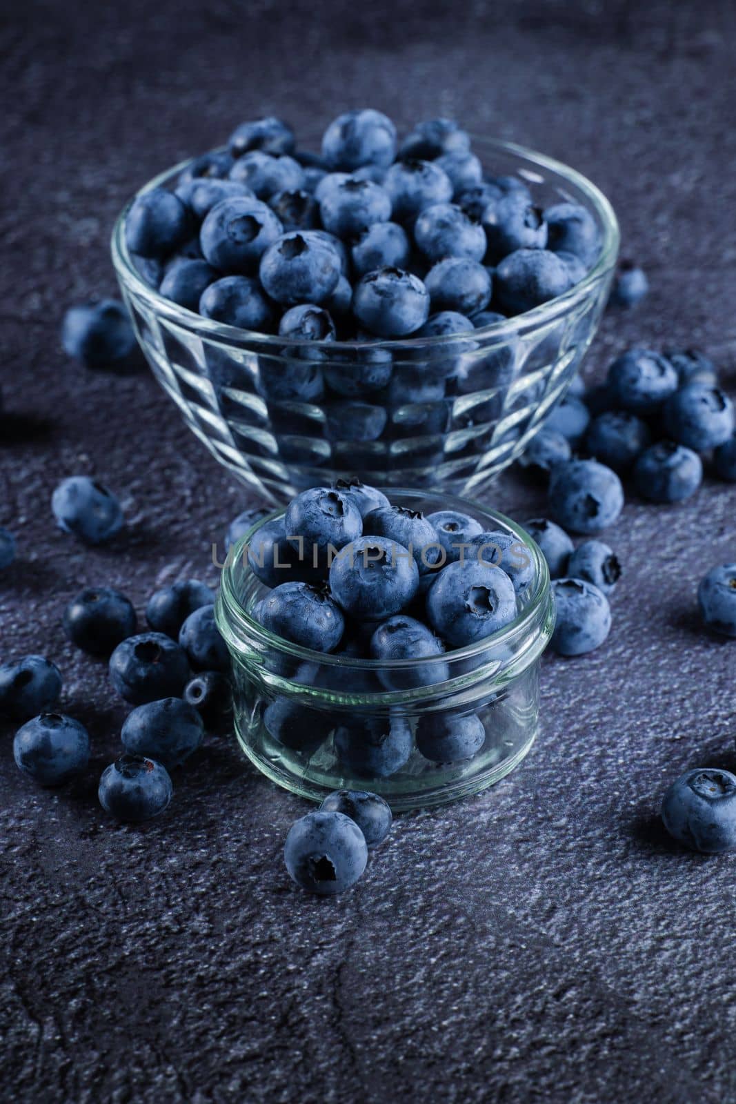 Blueberries organic natural berry on dark background. Blueberry in glass bowl plate. by Rabizo