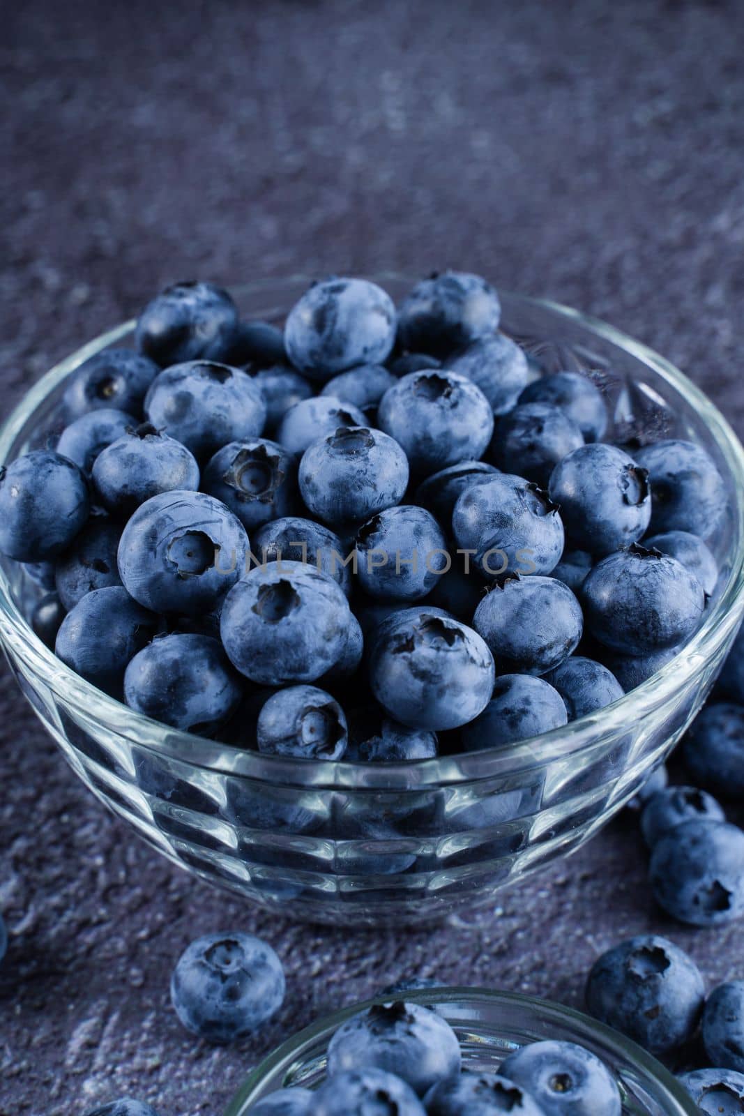 Blueberries organic natural berry on dark background. Blueberry in glass bowl plate. by Rabizo