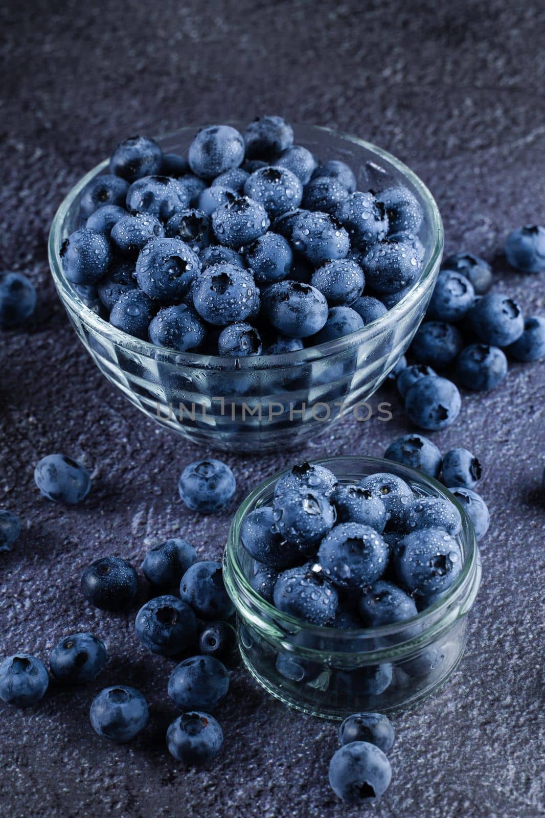 Blueberries organic natural berry with water drops on dark background. Blueberry in glass bowl plate