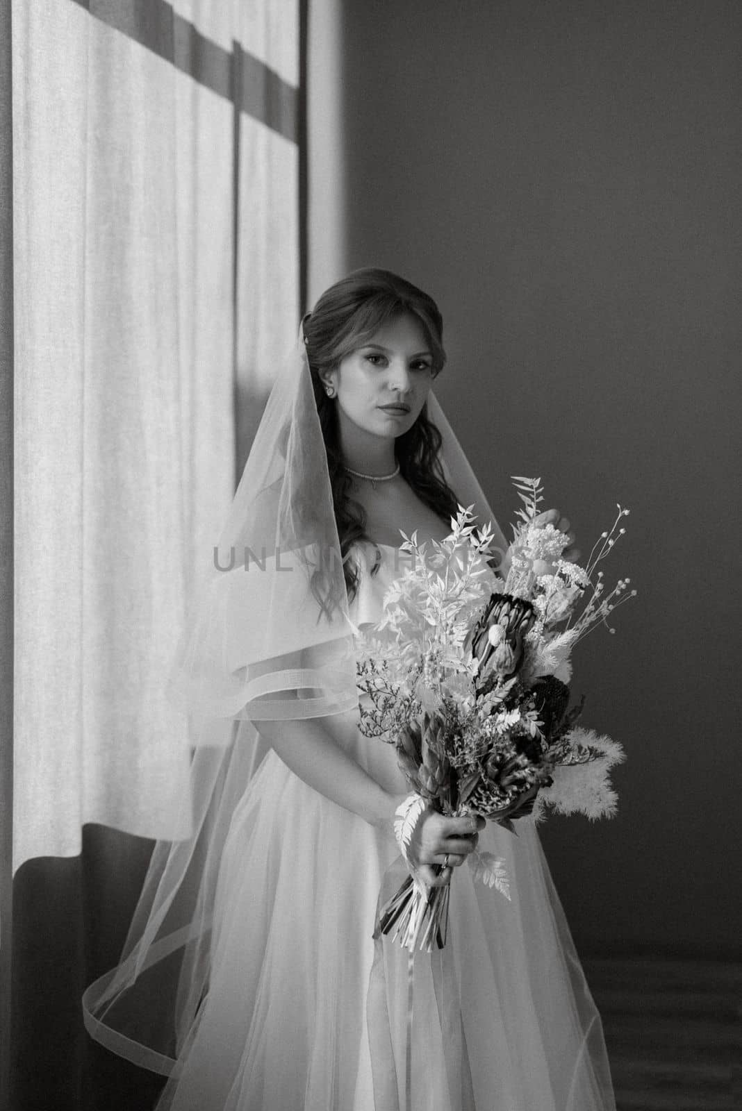 portrait of a bride girl with red hair in a white wedding dress with a bouquet