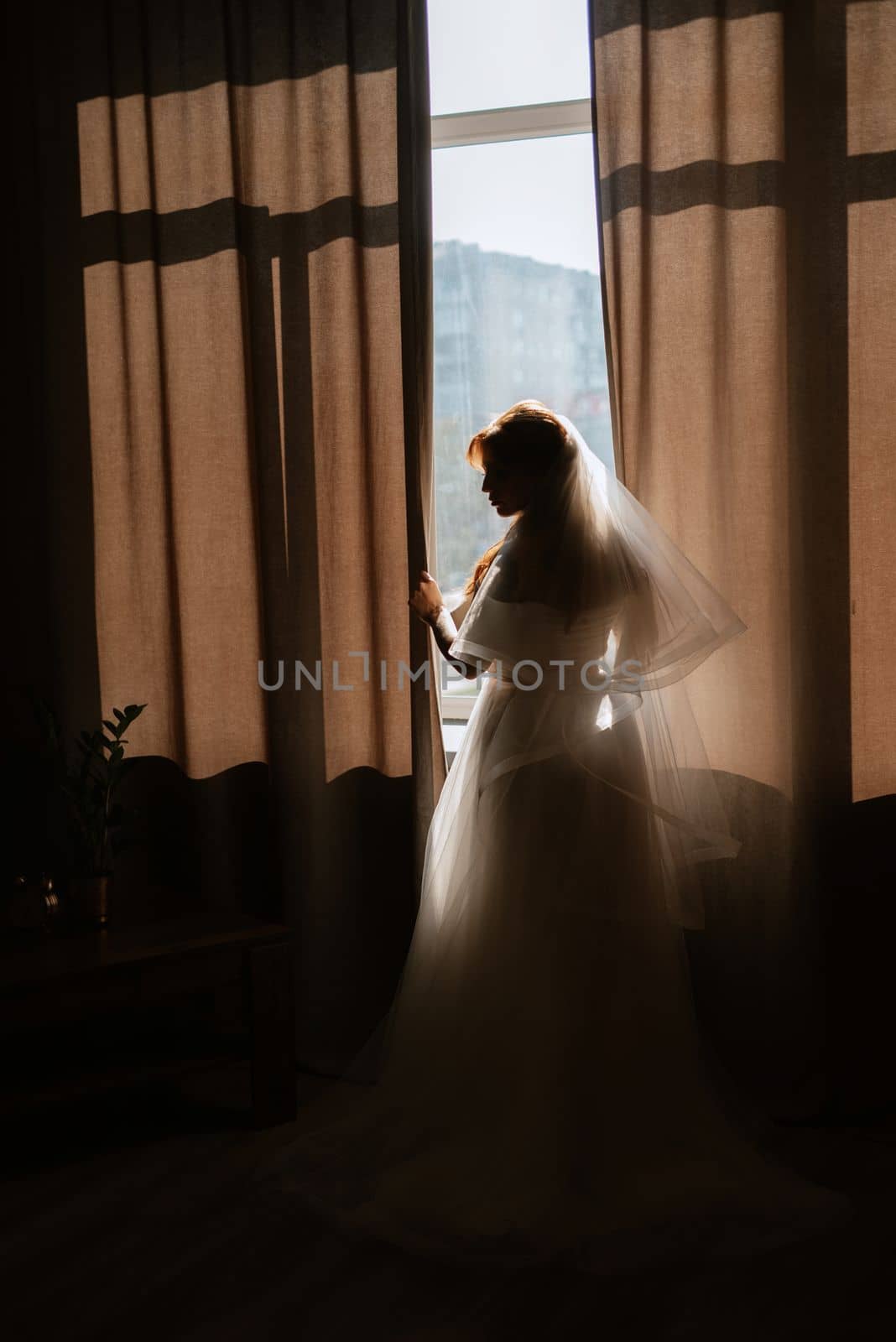 portrait of a bride girl with red hair in a white wedding dress with a bouquet