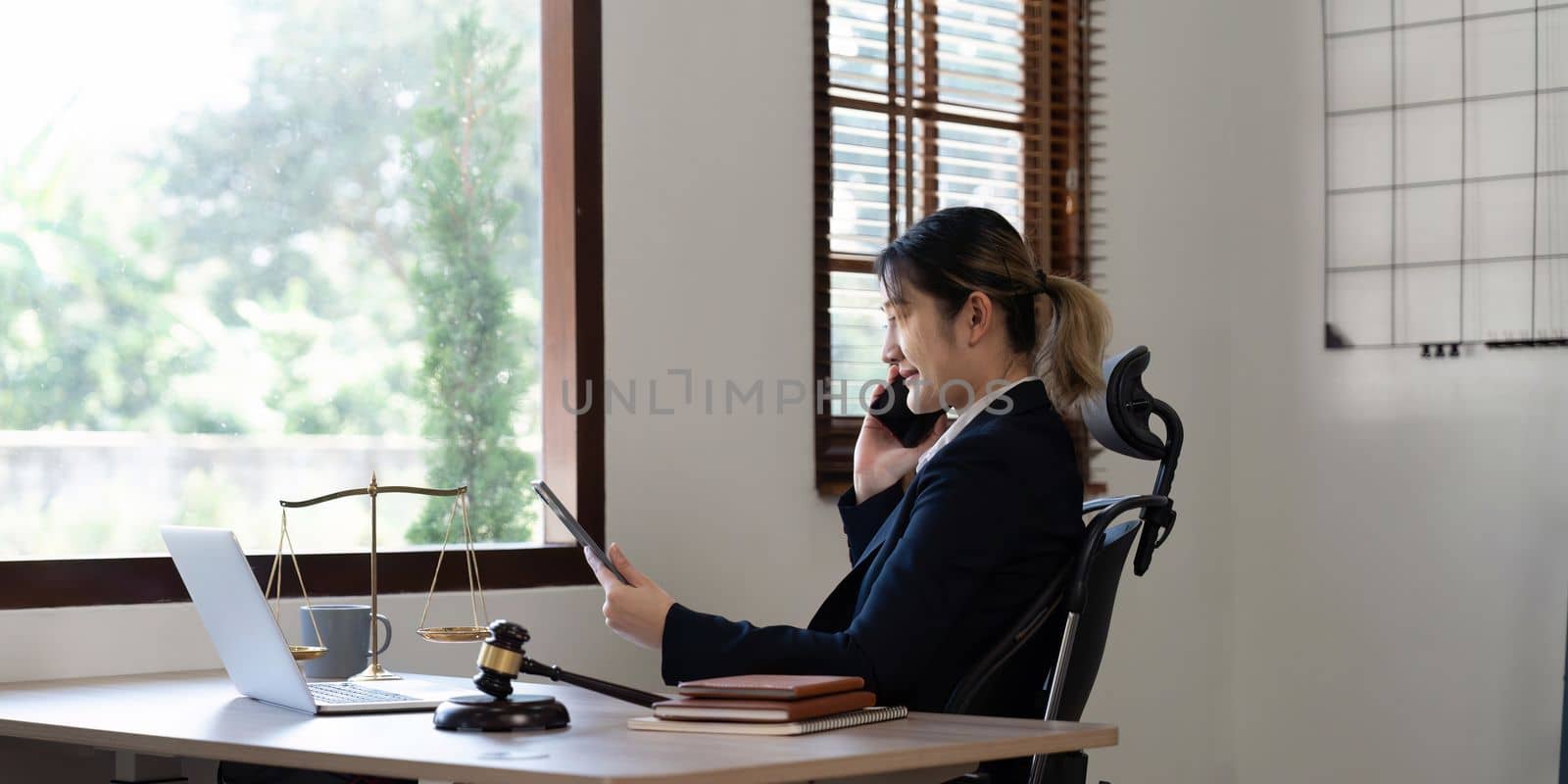 Attractive young lawyer in office Business woman and lawyers call phone in office. Law, legal services, advice, Justice and real estate concept.