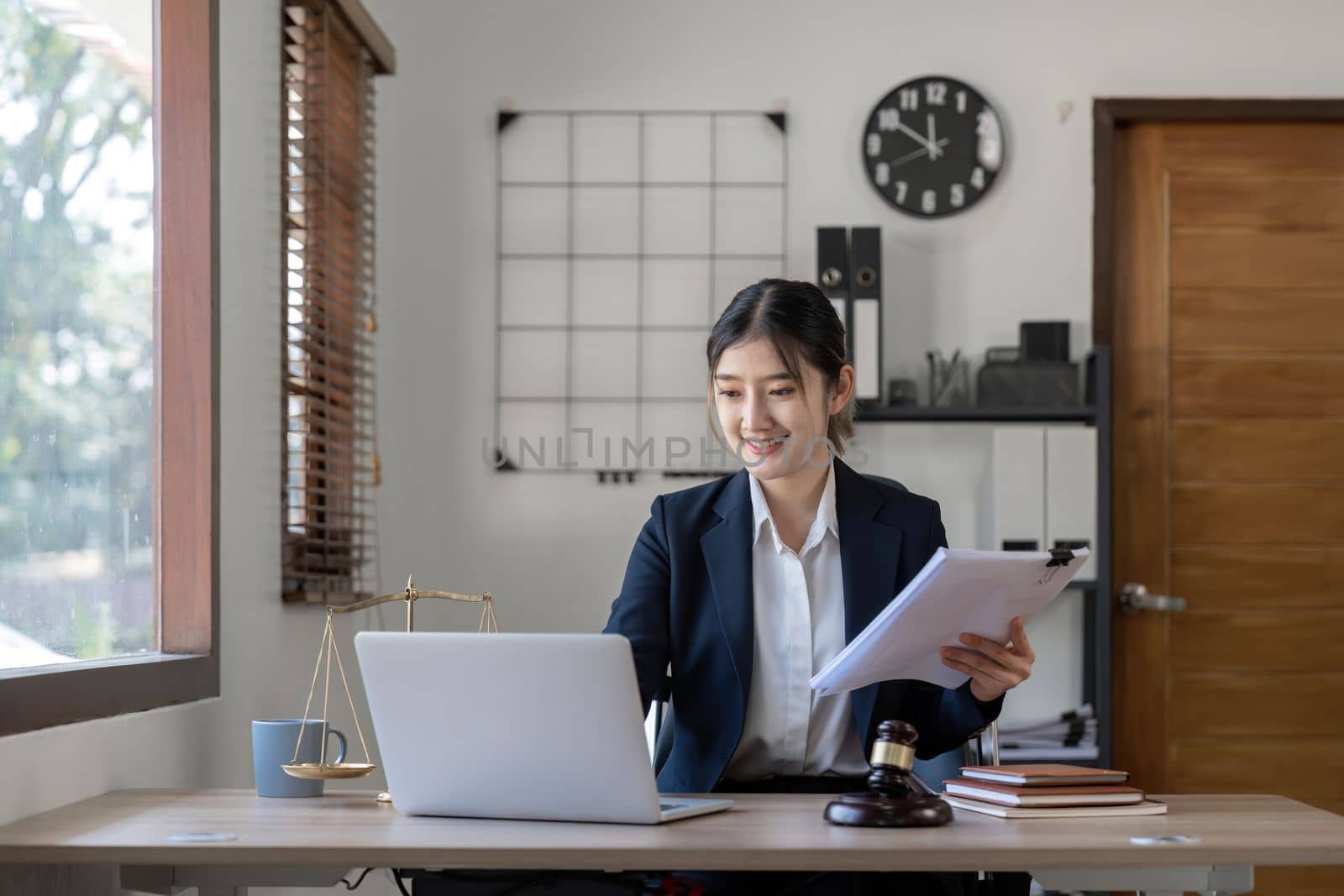Attractive young lawyer in office Business woman and lawyers discussing contract papers with brass scale on wooden desk in office. Law, legal services, advice, Justice and real estate concept.