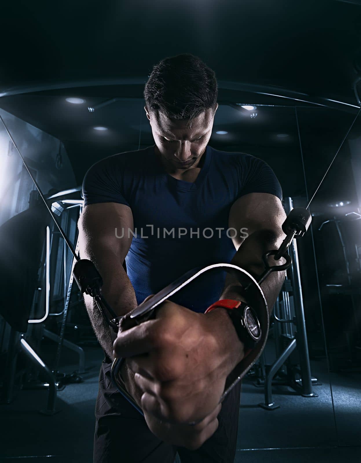 athlete doing exercises in the gym pulling the tross , closeup, tight t-shirt, creative photo