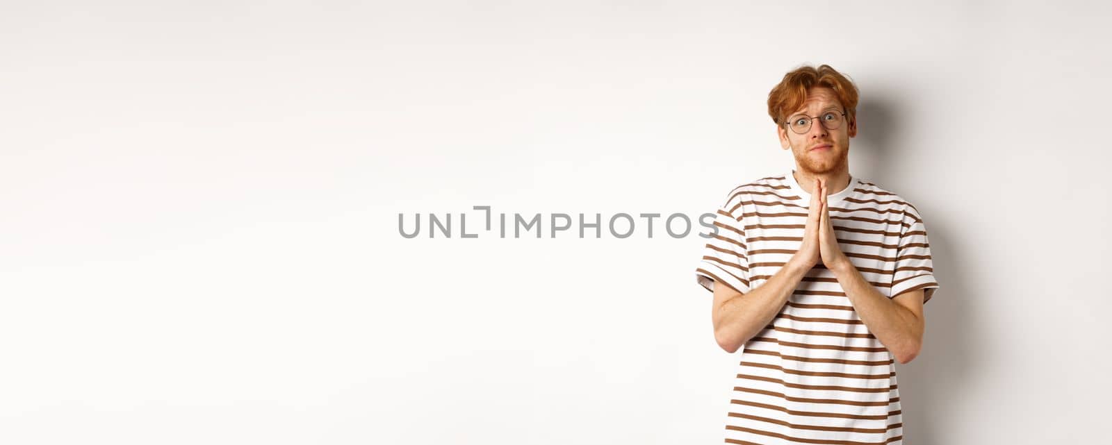 Cute redhead man in glasses asking for help, pleading and looking clingy at camera, begging for favour, white background by Benzoix