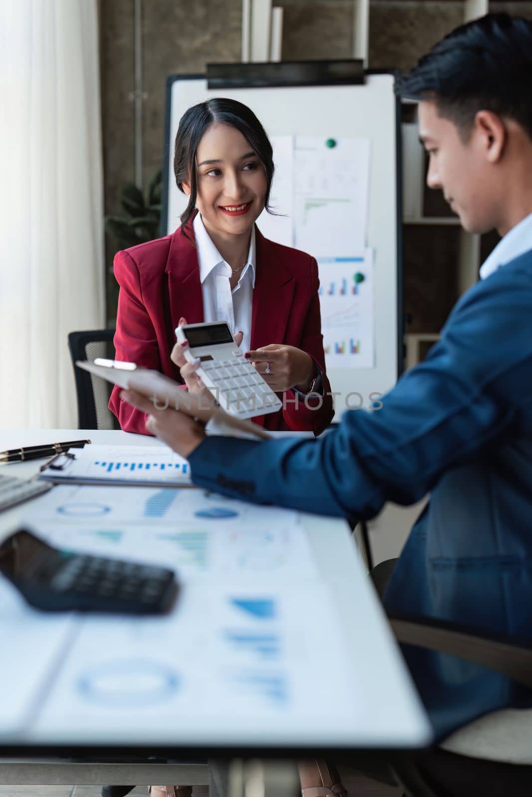 Beautiful business woman consultant talking with asian business person at meeting room with new financial market. Accounting concept.