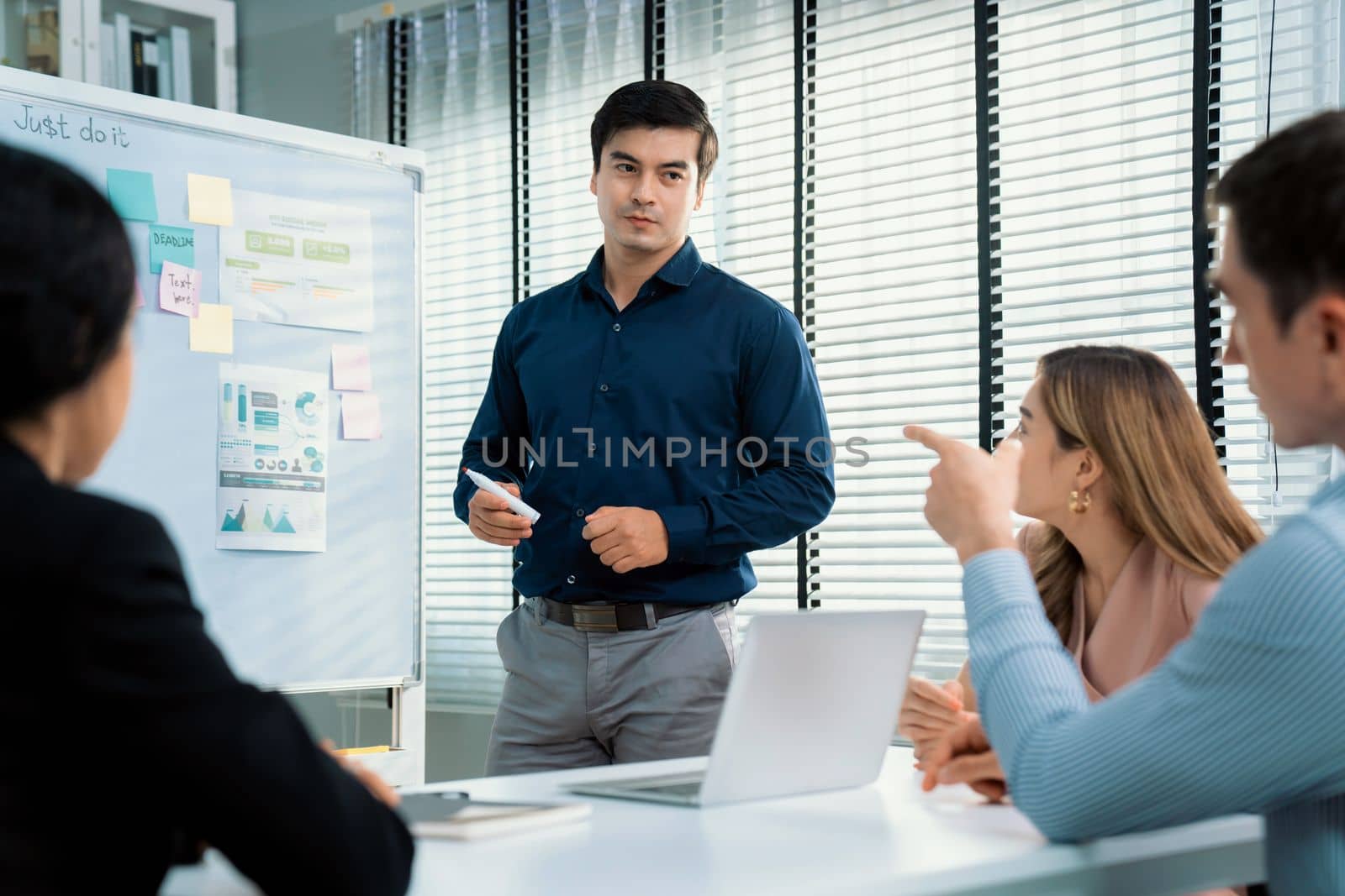 Competent office workers from various nationalities are debating, discussing and brainstorming in the meeting room. A group of employees is collaborating to achieve their business objectives.