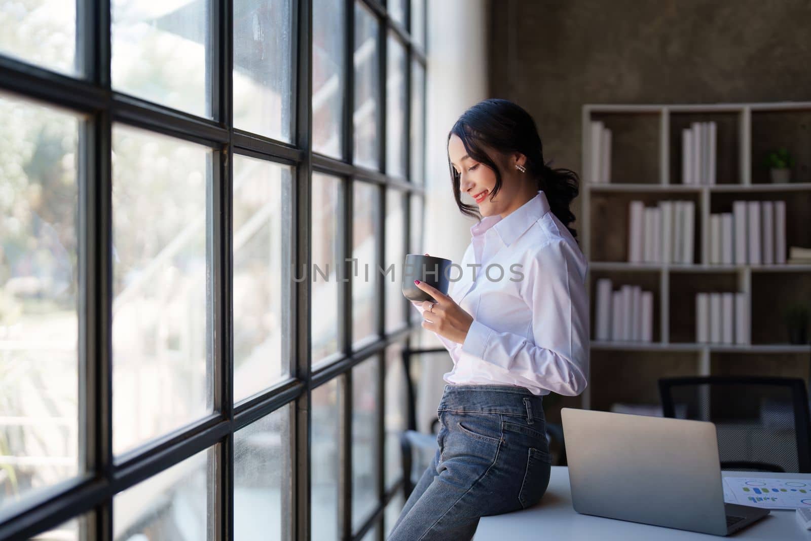 Portrait of Smiling asian business woman with laptop computer in office. Woman in suit at office.