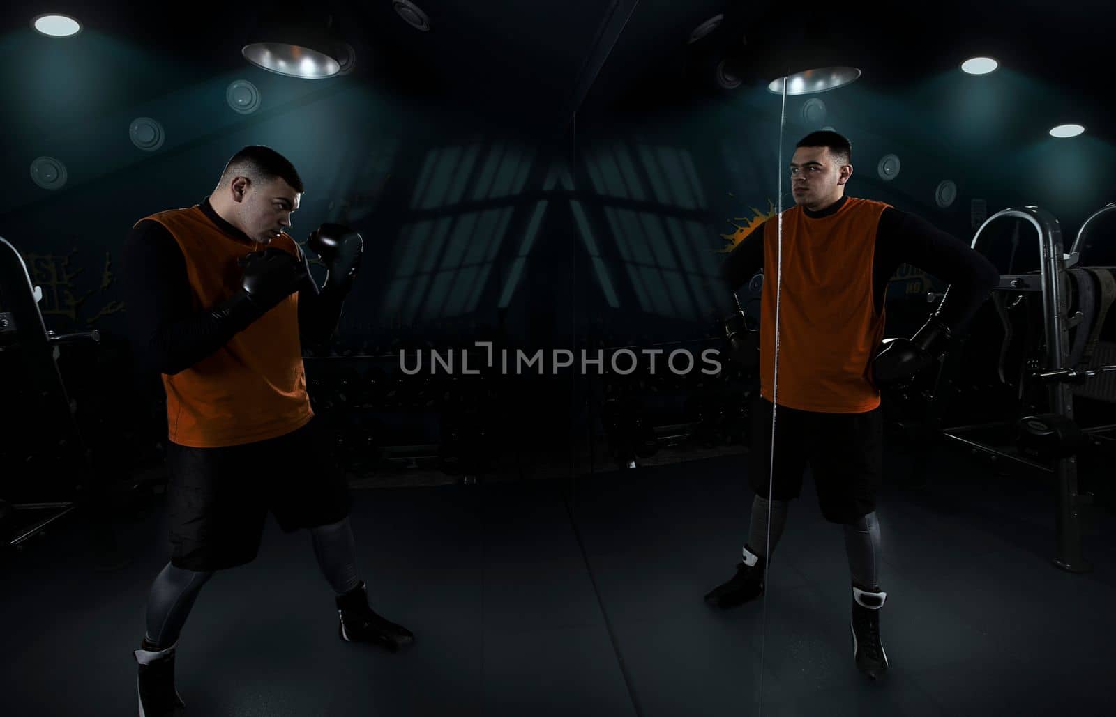 sportsman boxer trains with himself in front of a mirror with his reflection in anticipation of a fight set up positively confident in success tired and contented strong creative photo. High quality photo