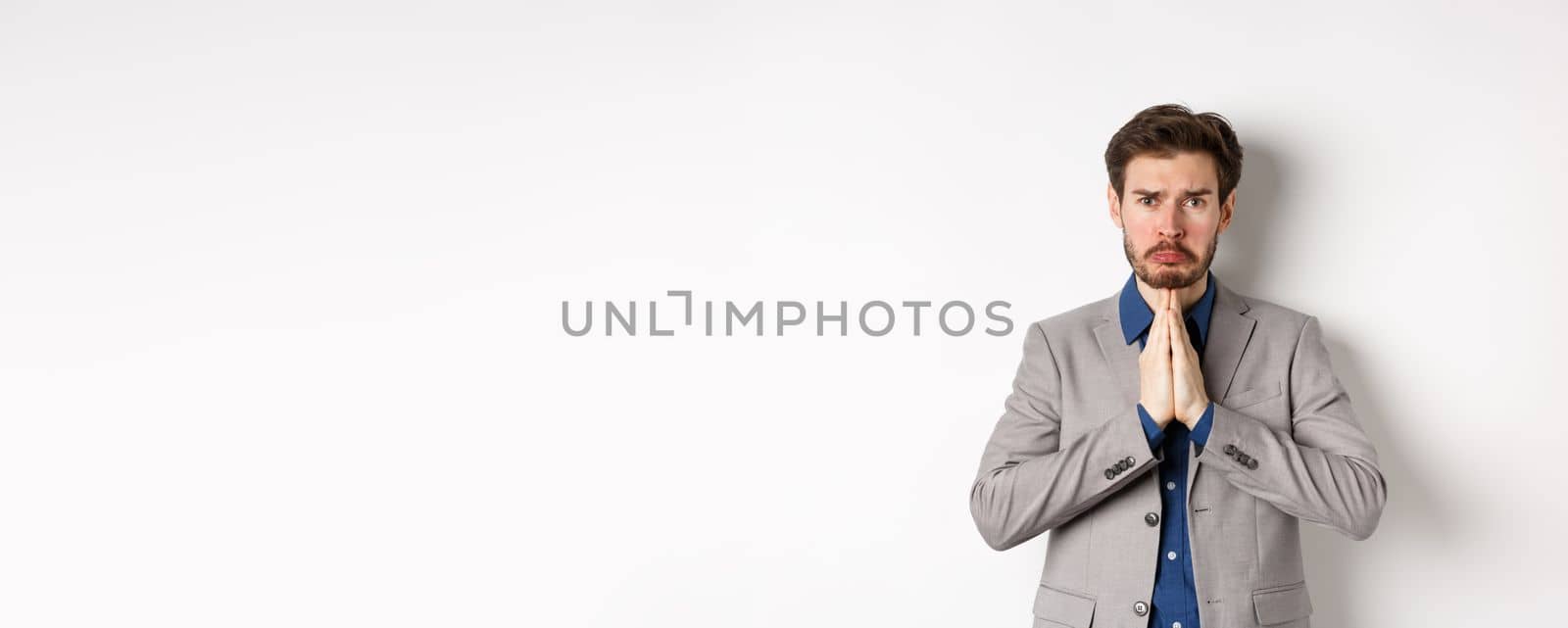 Miserable whining businessman asking for loan, need help and begging you, sobbing and say please with sad face, standing on white background, ask for forgiveness by Benzoix