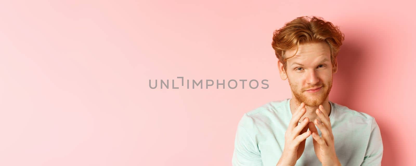 Close up of funny bearded man with red hair pitching a perfect plan, smiling and steeple fingers, scheming something, standing devious against pink background by Benzoix