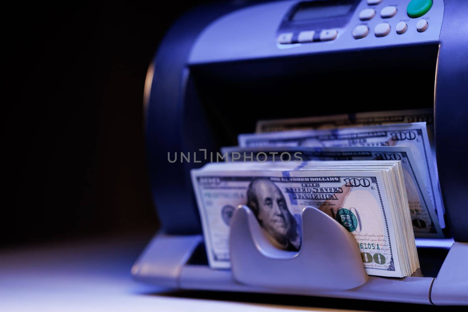 Currency counting machine counting dollar banknotes. Bank automatic equipment for counting paper money. USA federal fed reserve note fragment. Closeup cash money counting equipment by uflypro