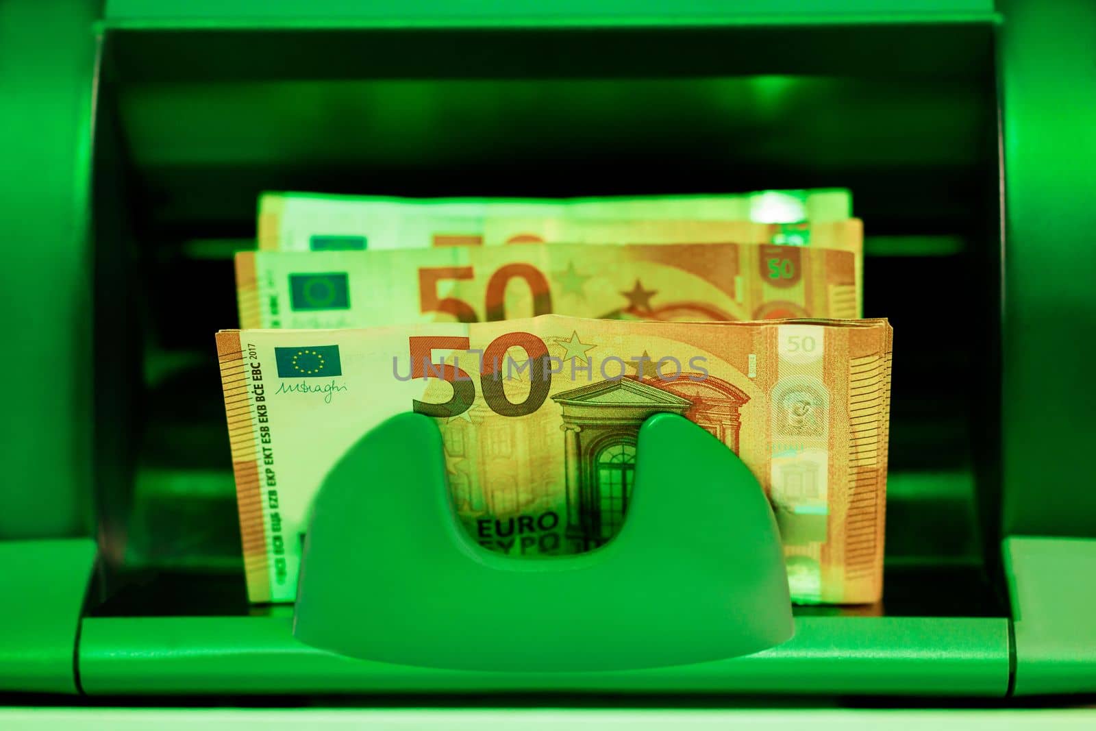 Money counting equipment for paper money calculation. Automatic mechanism for bank financial operations. Paper currency detector. Close up of euro banknotes while being counted by uflypro