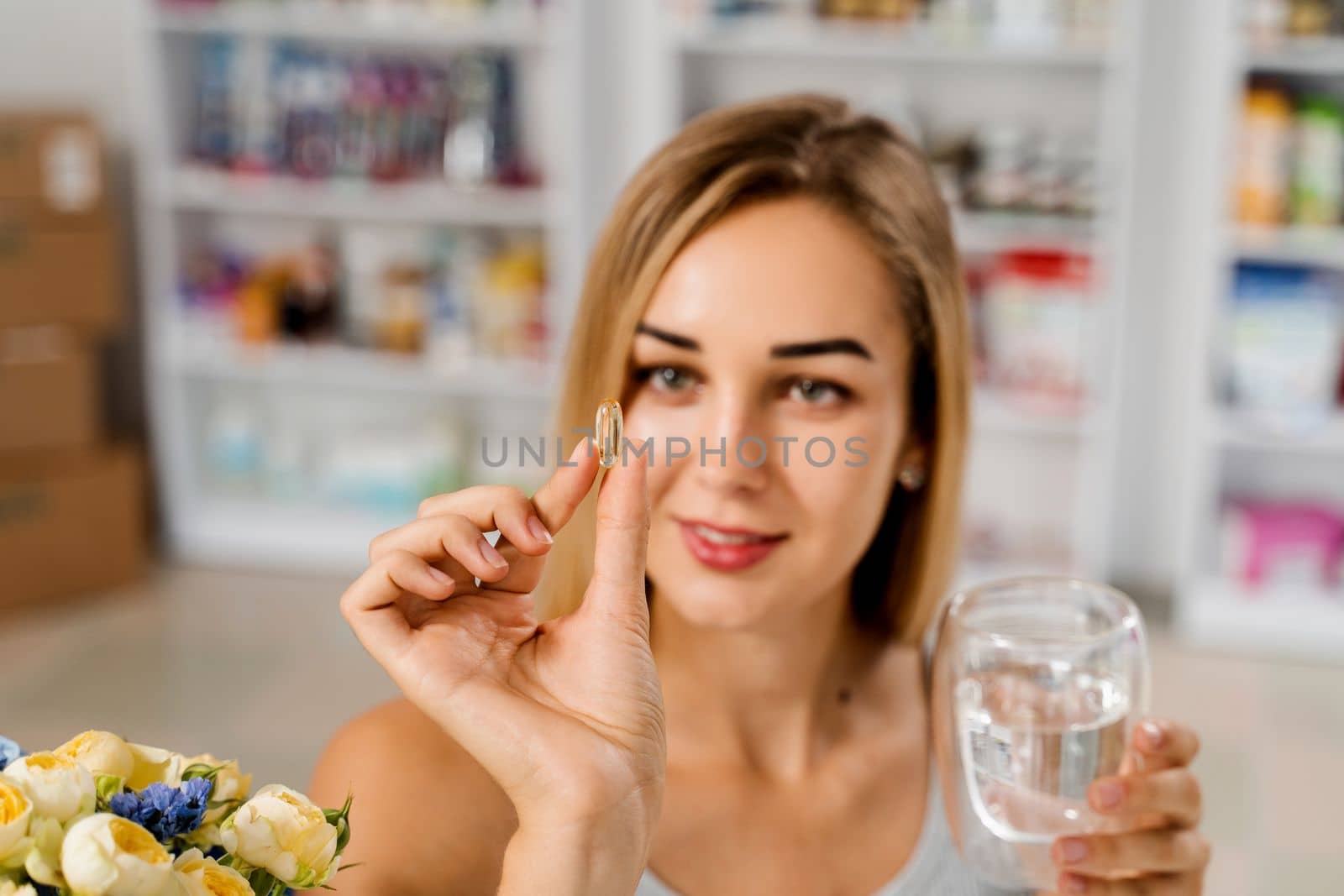 Girl with Omega 3 pill of fish fat oil in hands. BADS capsule of biologically active dietary supplements. Vitamin D for building and maintaining healthy bones. by Rabizo