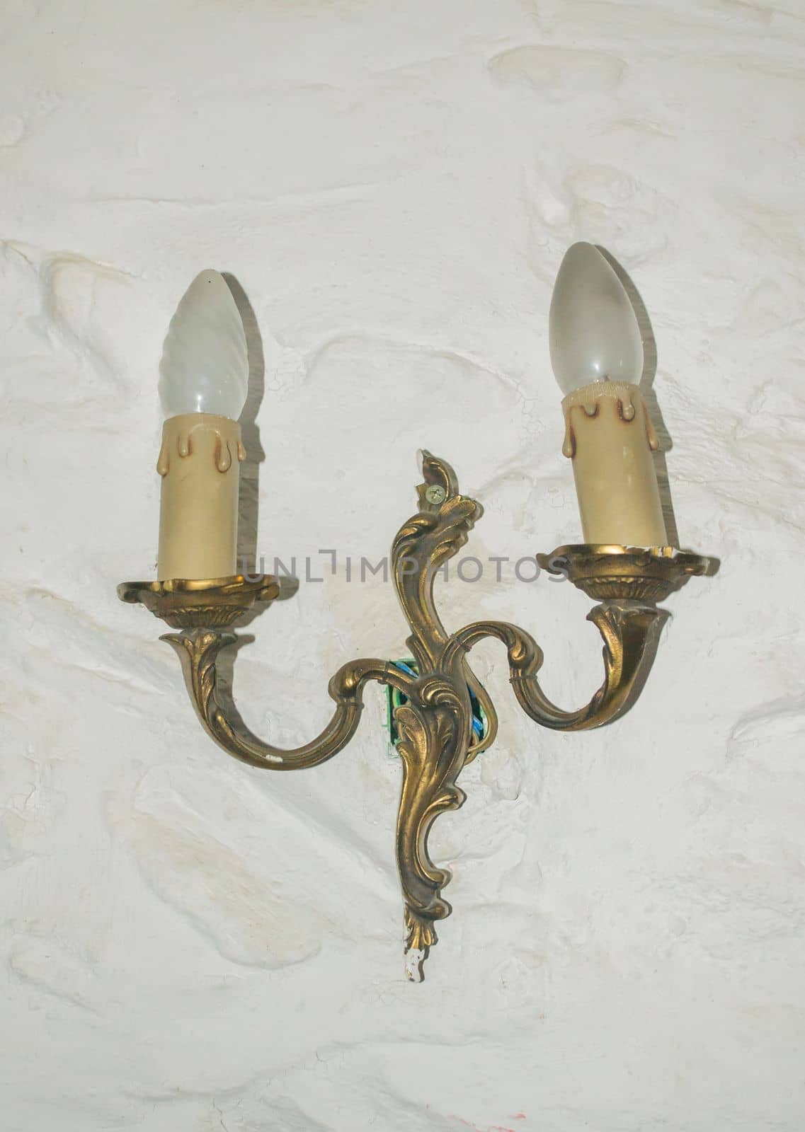 Antique candlesticks with candles hanging on the wall
