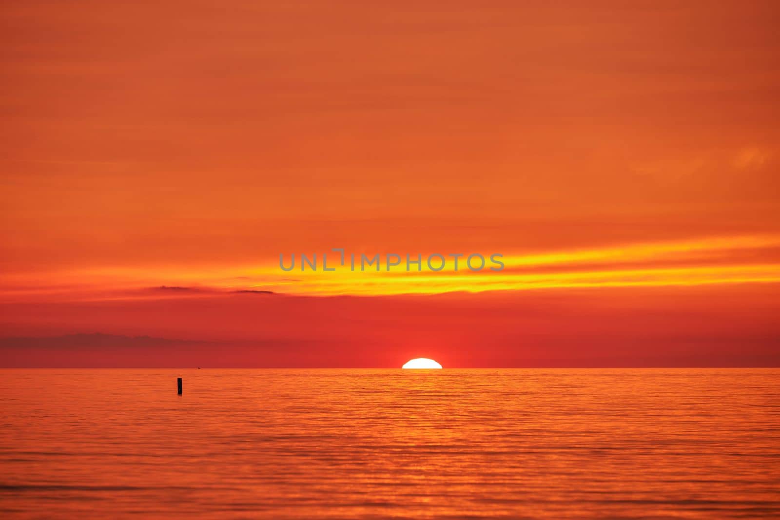 Epic crimson orange sunset cloud sky background at Wasaga Beach with sky and water. Sky replacement photo.