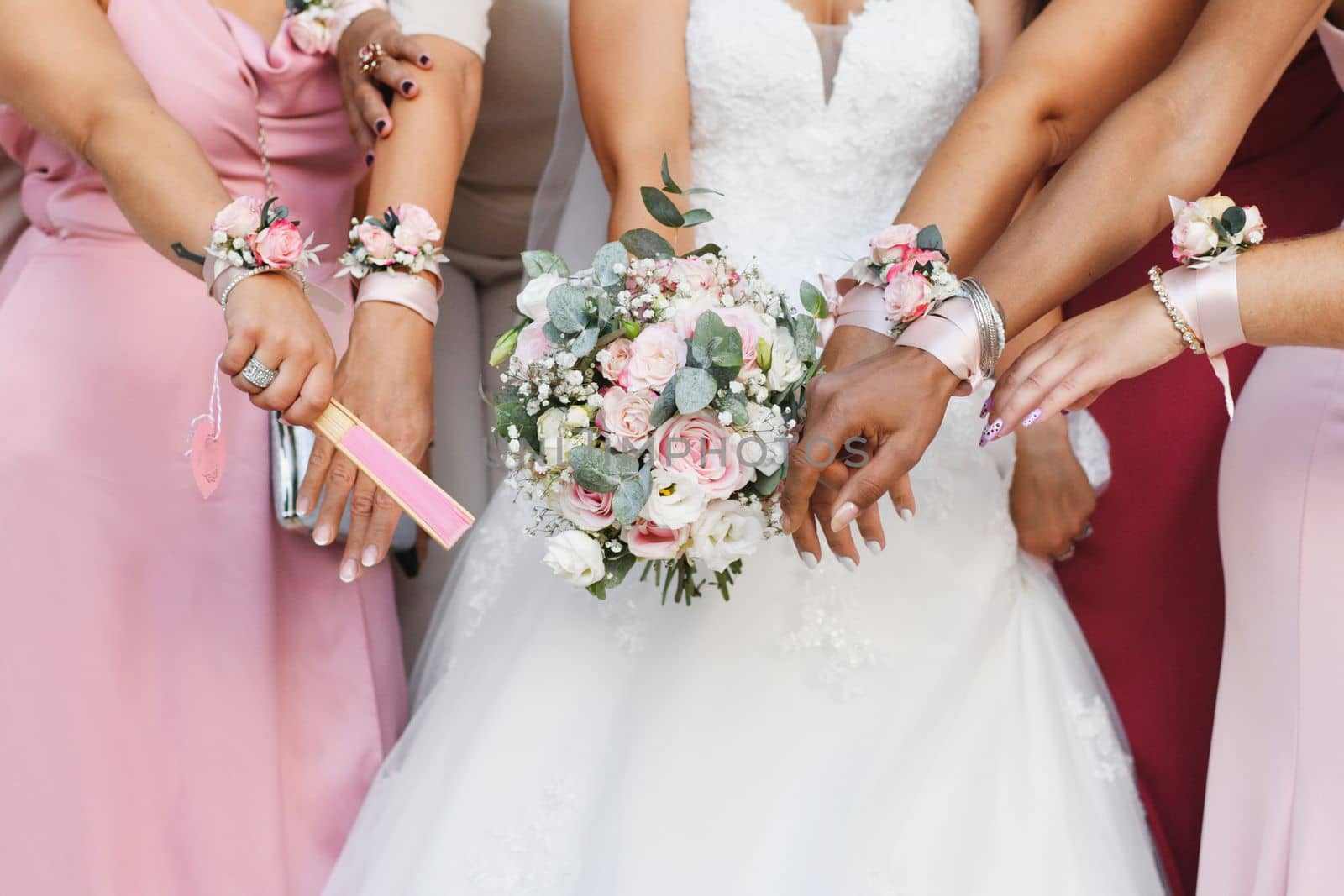 Bride with a bouquet and bridesmaids in identical dresses and bracelets