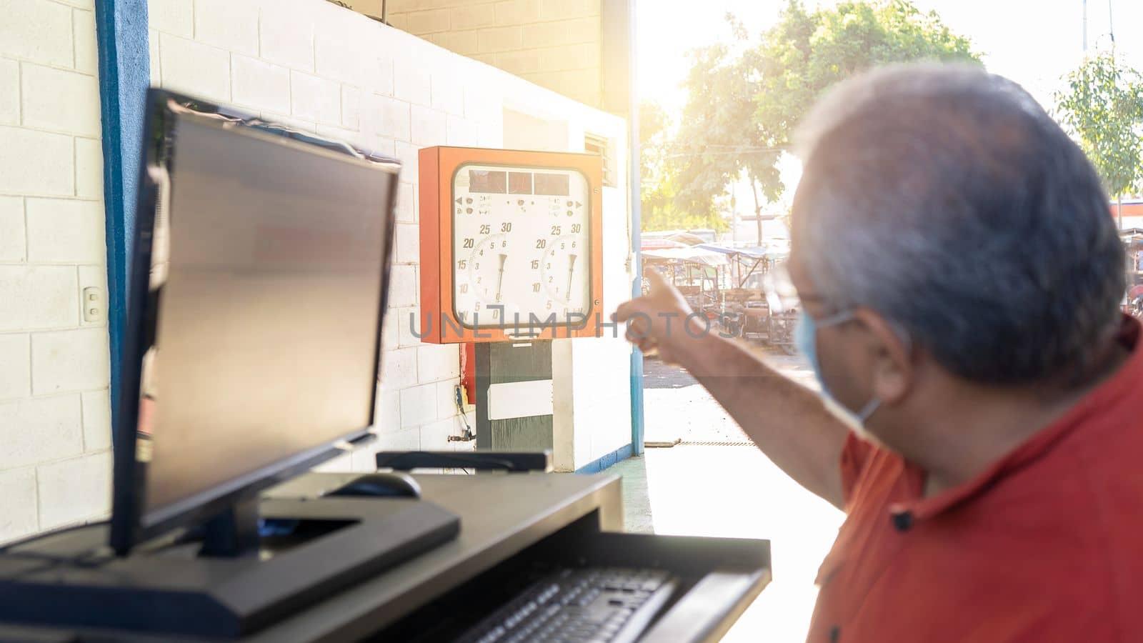 Mature Latino worker pointing at mechanical inspection machines