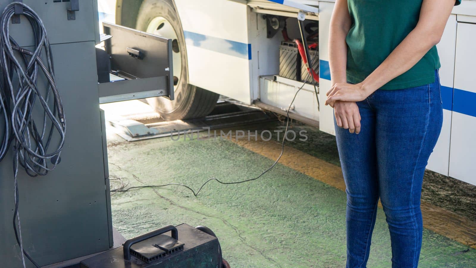 Latin woman mechanic checking the proper functioning of a bus by cfalvarez