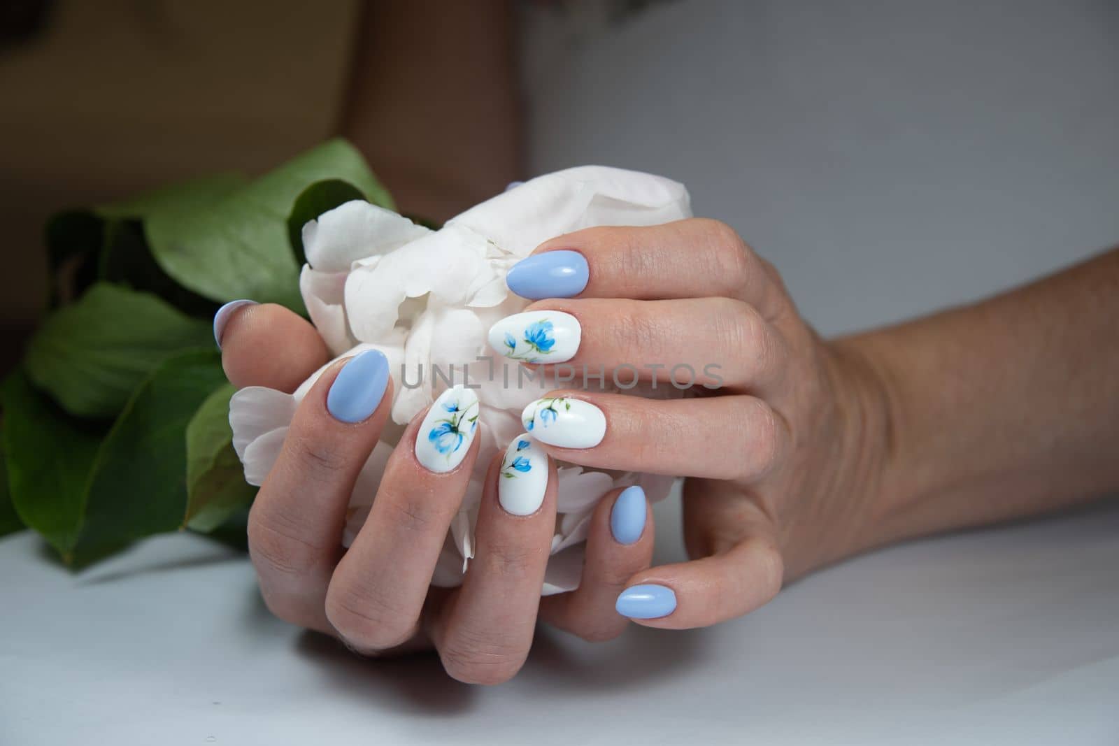 girl with a beautiful white blue manicure with a bouquet of delicate peonies, . High quality photo