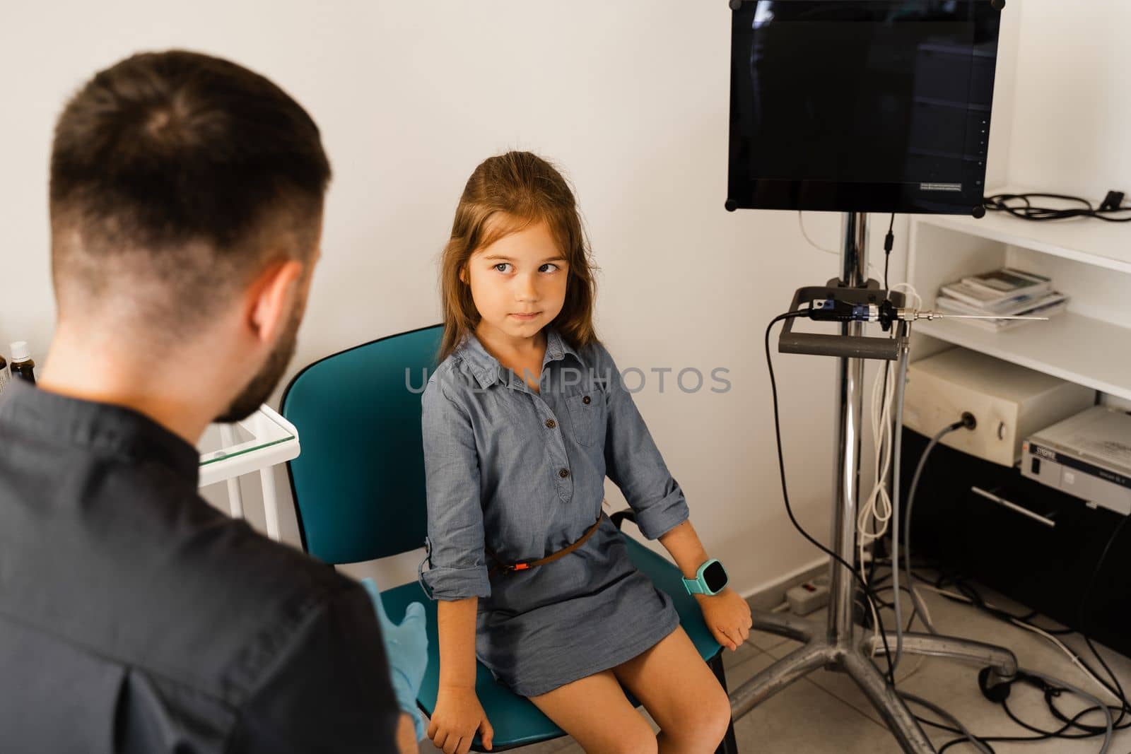 Consultation of kid with a pediatric otolaryngologist in a medical clinic. Nose examination of the child