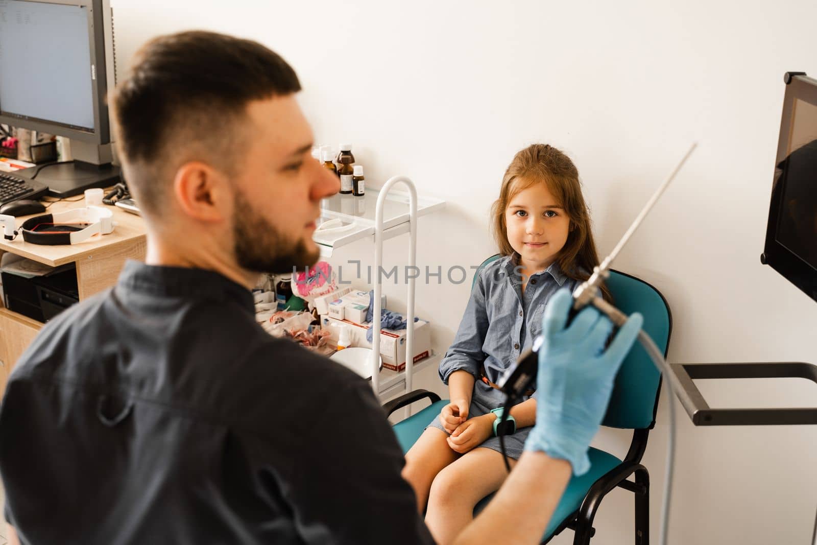 Doctor otolaryngologist with rhinoscope for endoscopy. Child consultation before nasal endoscopy. Examination of child nose and diagnosis of disease