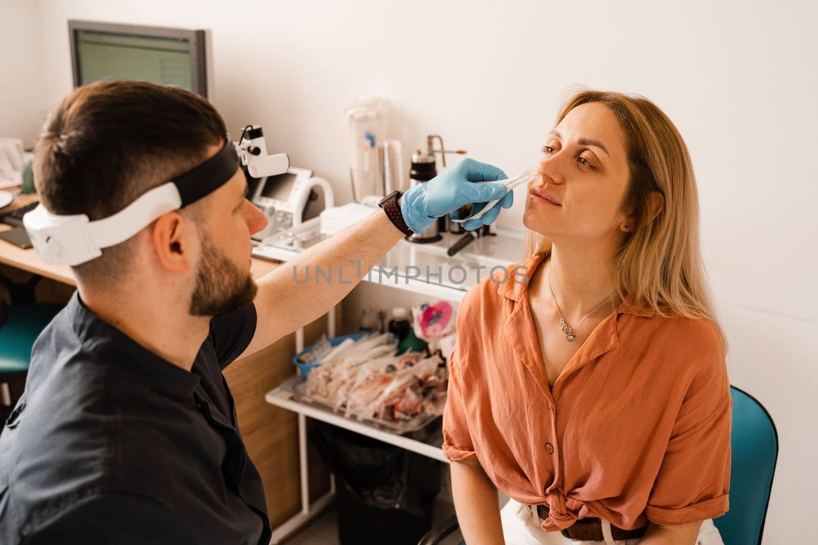 Rhinoscopy of woman nose. Consultation with doctor. Otolaryngologist examines girl nose before procedure of endoscopy of nose. by Rabizo