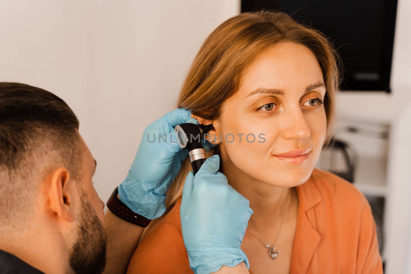 Close-up examination of womans ear with otoscope. Otoscopy. Visit to ENT doctor and consultation