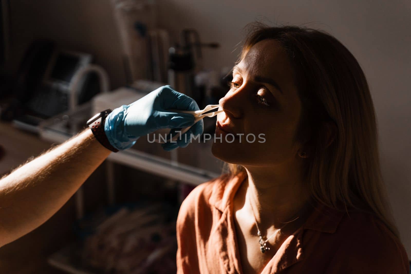 Rhinoscopy of woman nose. Consultation with doctor. Otolaryngologist examines girl nose before procedure of endoscopy of nose