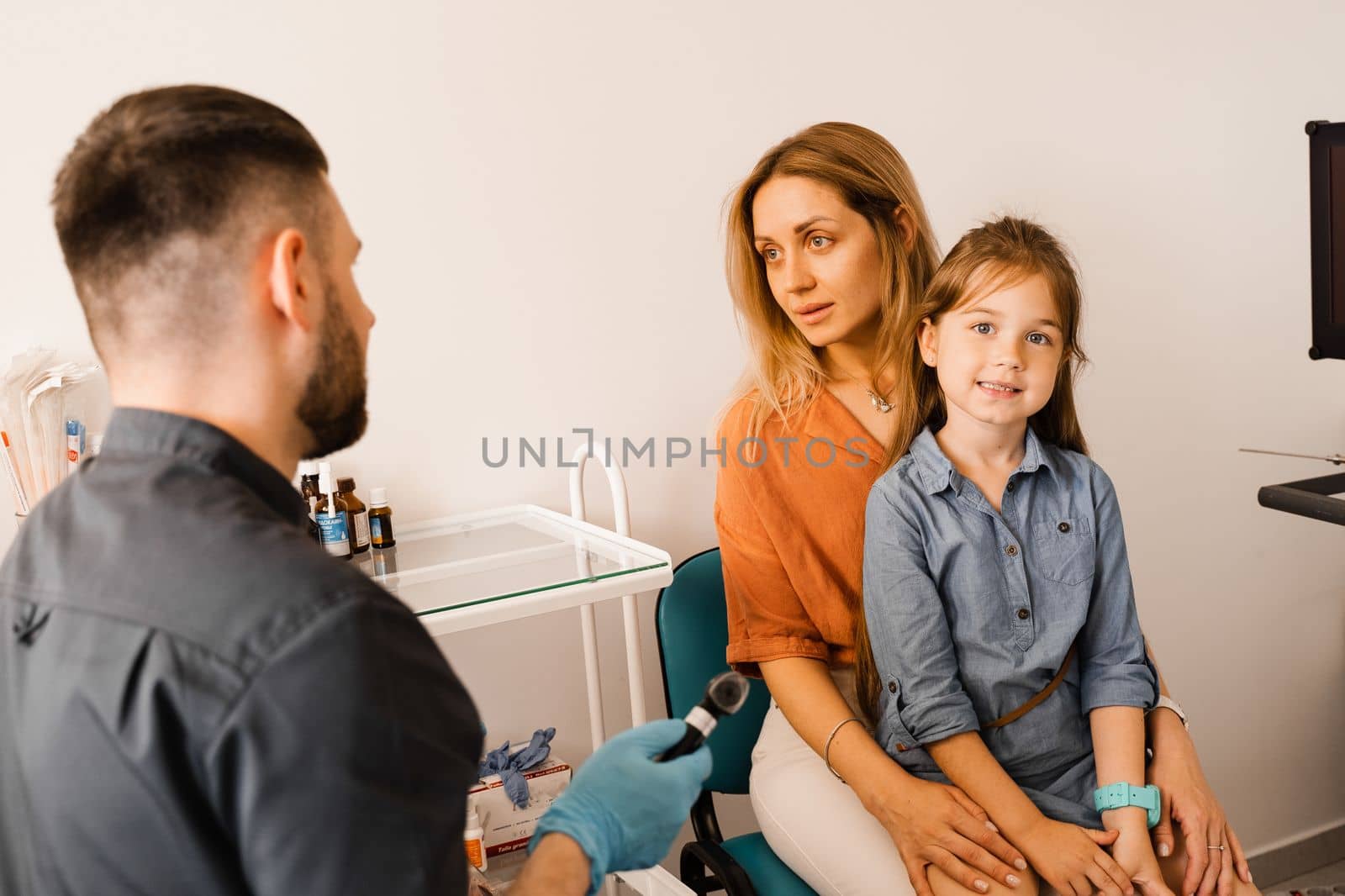 Woman and her child daughter visit ENT doctor. Consultation about endoscopy of nose for family with otolaryngologist in a medical clinic. by Rabizo