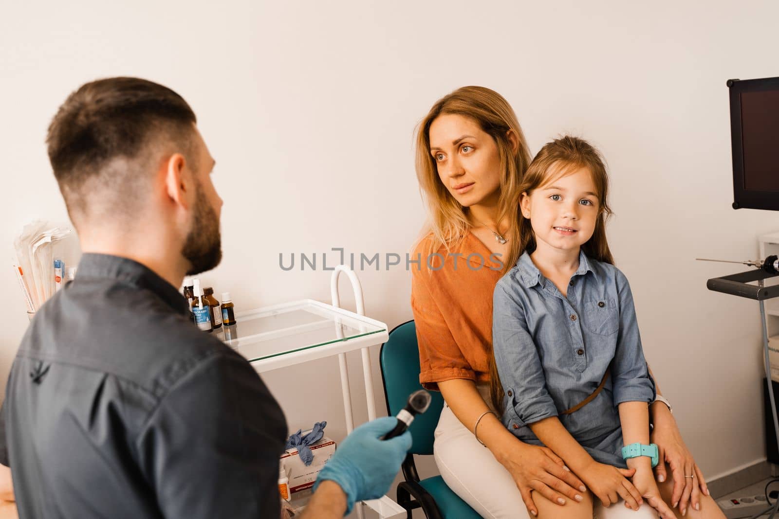 Woman and her child daughter visit ENT doctor. Consultation about endoscopy of nose for family with otolaryngologist in a medical clinic