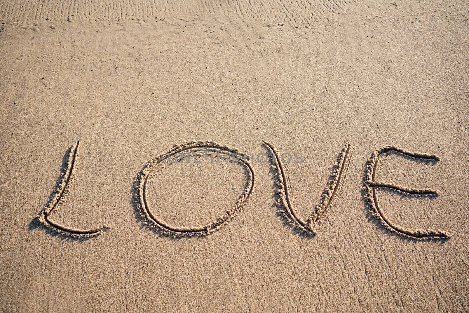 Written word LOVE on sand with copy space by papatonic