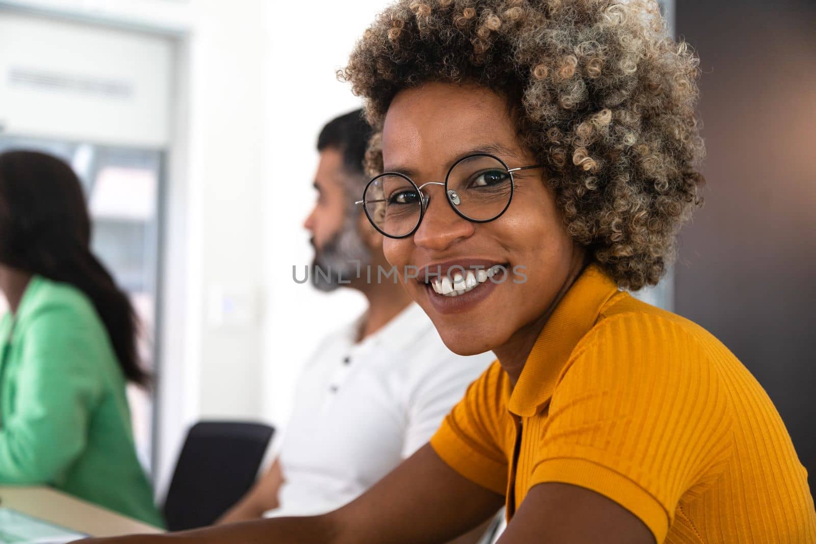 Portrait of smiling African American woman looking at camera in business meeting at the office. Copy space. by Hoverstock
