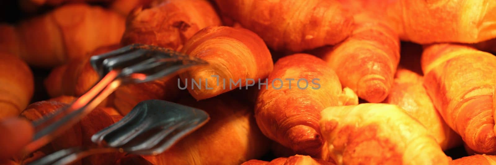 Freshly baked golden brown french croissants on bakery showcase. Delicious sweet croissants concept