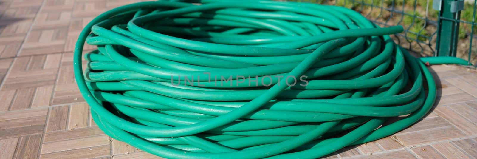 Coiled garden hose lies on ground closeup by kuprevich