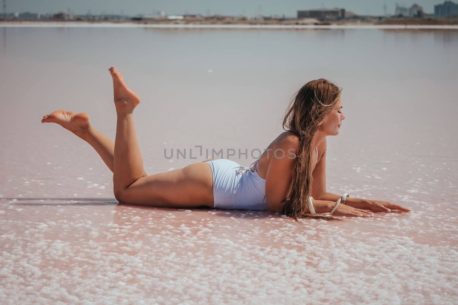 Salt mining. Salty pink lake with crystals of salt. Extremely salty pink lake, colored by microalgae with crystalline salt depositions