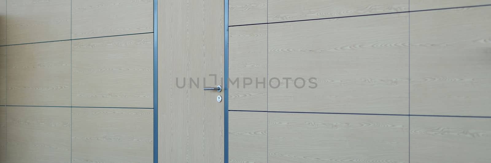 Light brown beige wall with door in business center. Airport or station door for staff concept