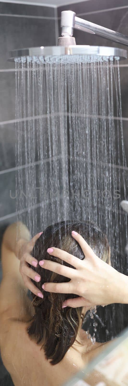 woman takes cool shower and washes hair. Body hygiene concept