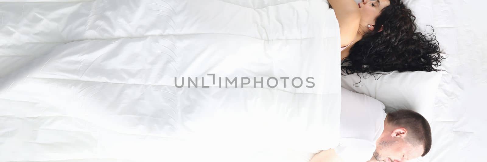 Man and a woman lie in bed facing away from each other. Crisis of family intimate life concept